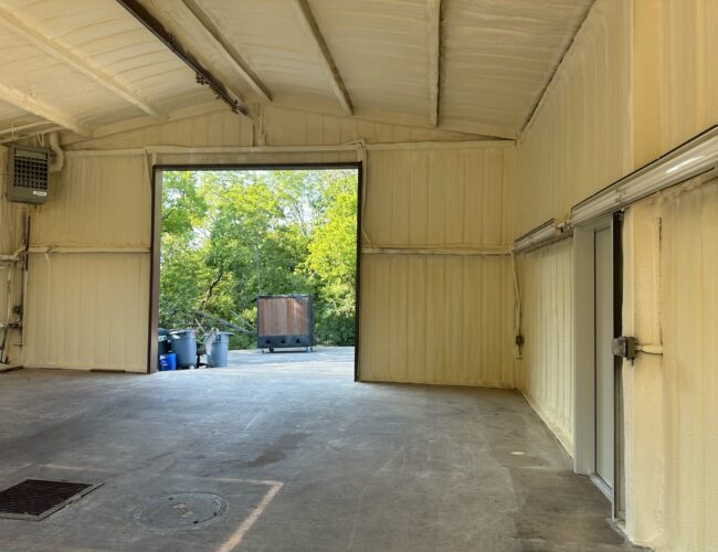 Warehouse interior with spray foam insulation on walls and ceiling.